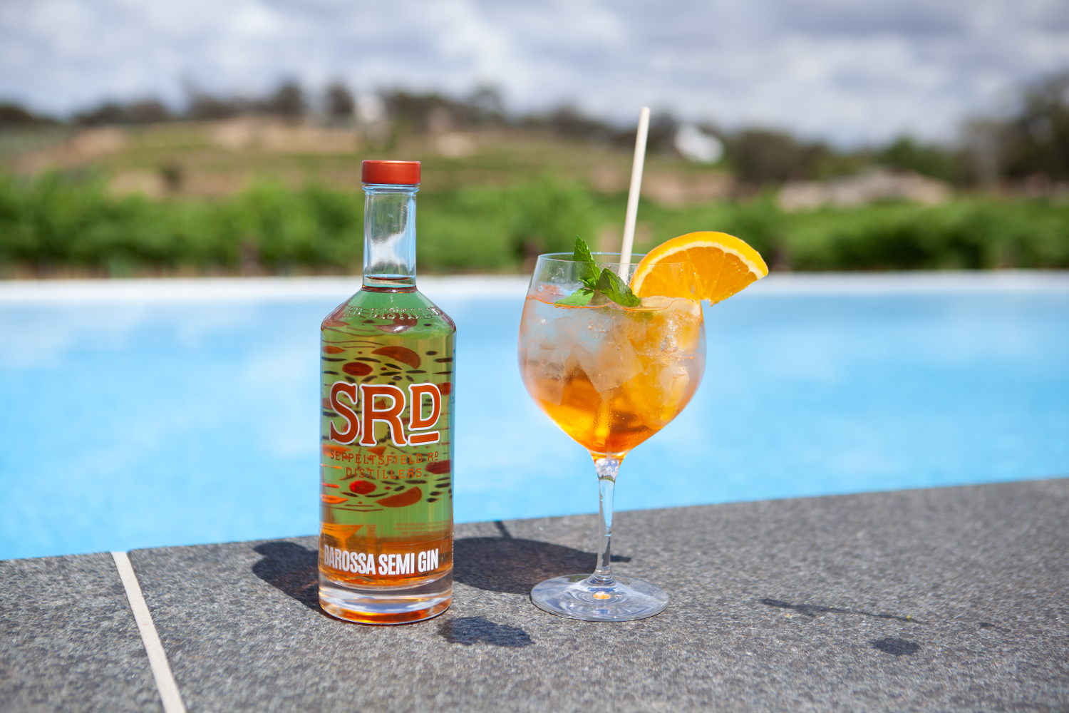 Bottle of Barossa Semi Gin and spritz cocktail poolside near a vineyard 